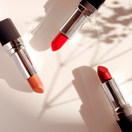 Three lipsticks in different colors on a light background