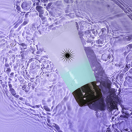 Bottle with a black starburst design on a purple water background