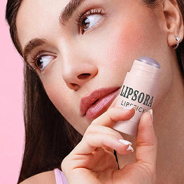 Person holding a Lipsora lip balm against a pink background